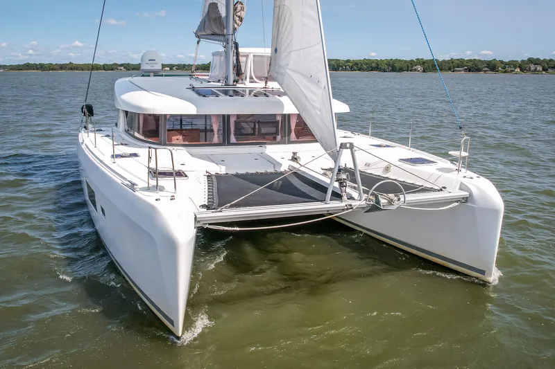 Reunited Yacht Photos Pics 2017 Lagoon 42 catamaran sailing on a calm lake under clear skies.
