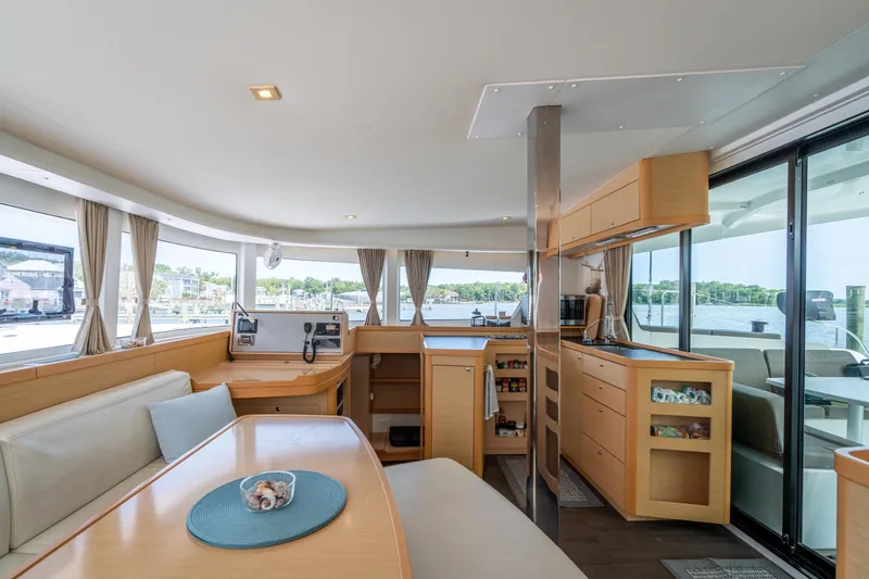 Reunited Yacht Photos Pics Interior of 2017 Lagoon 42 catamaran with modern kitchen and dining area, featuring panoramic windows.