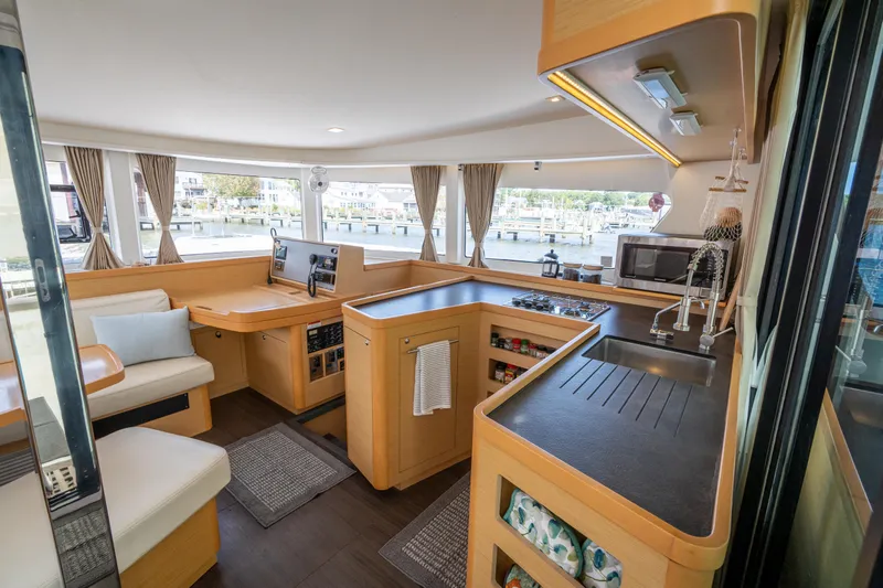 Reunited Yacht Photos Pics Interior of 2017 Lagoon 42 catamaran with modern kitchen and seating area.