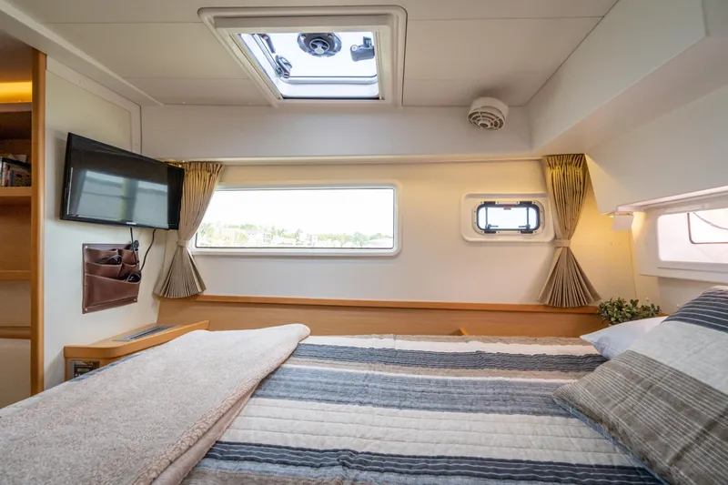 Reunited Yacht Photos Pics Luxurious cabin interior of 2017 Lagoon 42 catamaran with cozy bedding and natural light.