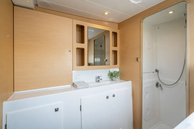 Reunited Yacht Photos Pics Modern bathroom interior on 2017 Lagoon 42 yacht with shower and wooden cabinetry.