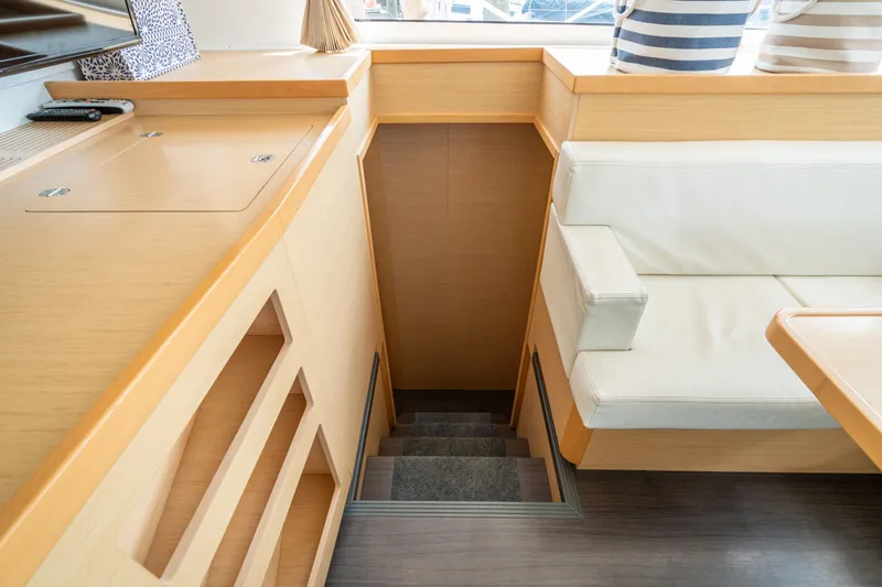 Reunited Yacht Photos Pics Interior of 2017 Lagoon 42 yacht with stairs, light wood, and white seating.