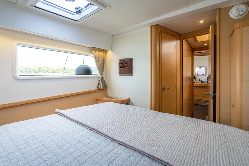 Reunited Yacht Photos Pics Luxurious interior of 2017 Lagoon 42 catamaran, featuring a cozy bedroom and modern bathroom.