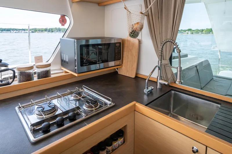 Reunited Yacht Photos Pics Modern kitchen in 2017 Lagoon 42 yacht with stove, microwave, and sink.