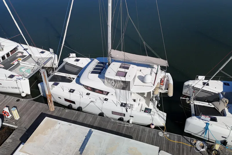 Reunited Yacht Photos Pics Aerial view of a 2017 Lagoon 42 catamaran docked at a marina.