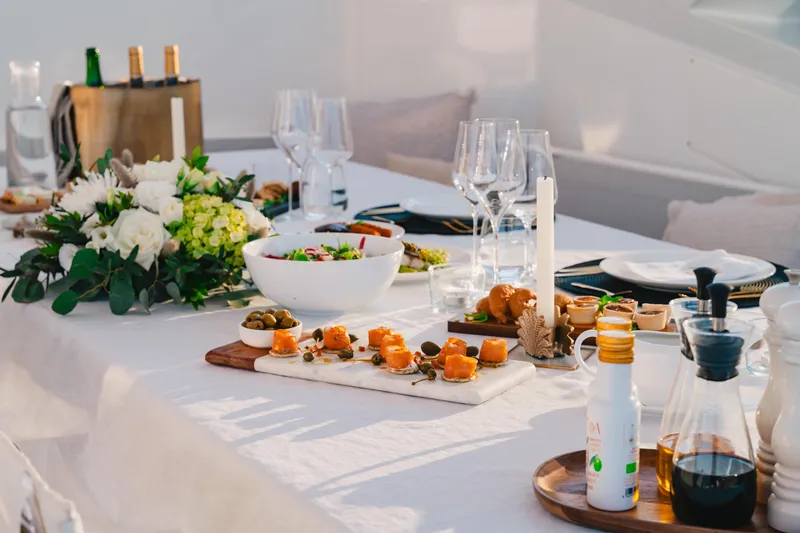  Yacht Photos Pics Elegant dining setup on Azimut Grande 32 Metri yacht, featuring gourmet appetizers and floral centerpiece.