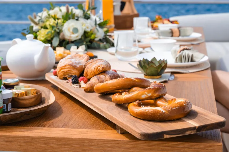 Yacht Photos Pics Luxurious breakfast setup on Azimut Grande 32 Metri yacht, featuring pastries and elegant tableware.