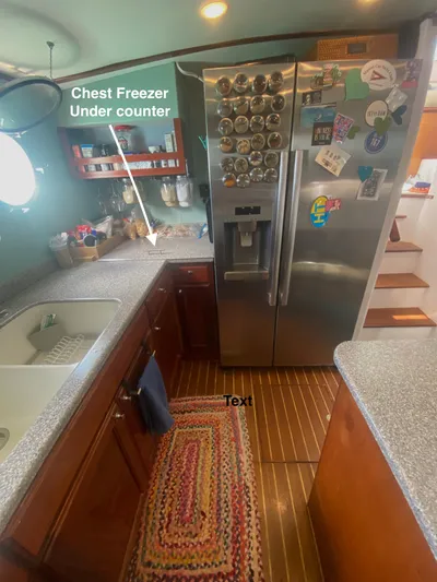 Korkzcrew Yacht Photos Pics 2008 Great Harbour N37 kitchen with stainless steel fridge, wooden cabinets, and under-counter chest freezer.