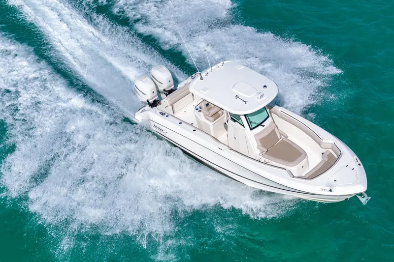  Yacht Photos Pics 2016 Boston Whaler 280 Outrage cruising on turquoise water, aerial view.