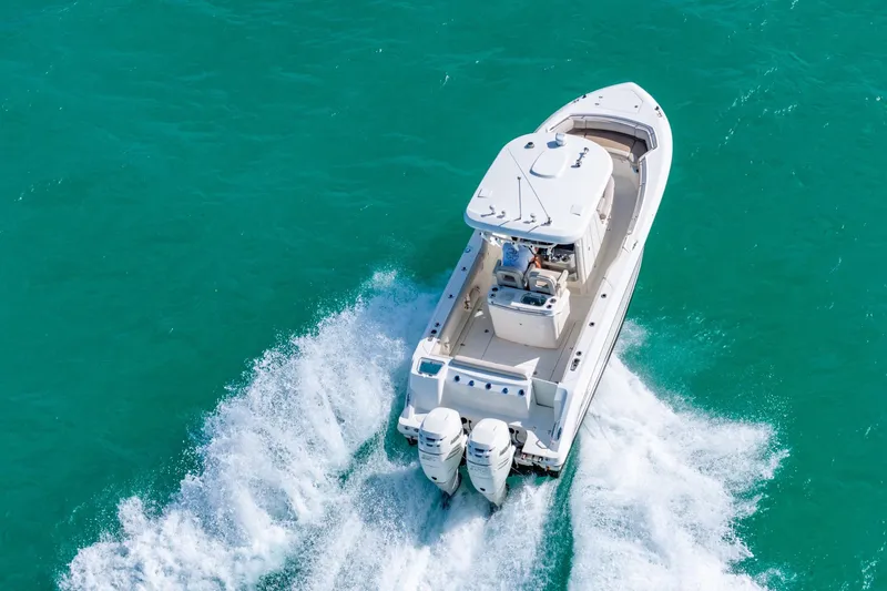  Yacht Photos Pics 2016 Boston Whaler 280 Outrage cruising on turquoise water, aerial view.