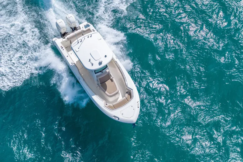  Yacht Photos Pics 2016 Boston Whaler 280 Outrage cruising on vibrant blue ocean waters.