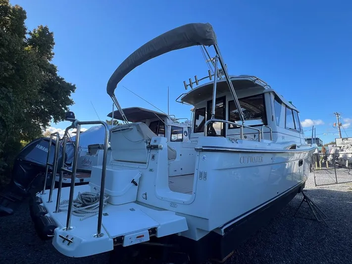  Yacht Photos Pics 2016 Cutwater C-28 boat with canopy, docked outdoors under clear blue sky.