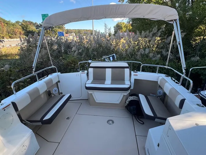  Yacht Photos Pics 2016 Cutwater C-28 boat interior with seating and canopy, surrounded by greenery.