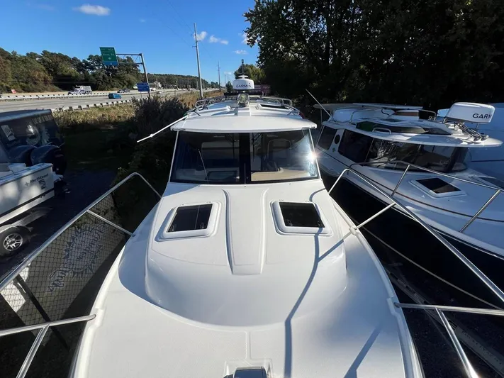  Yacht Photos Pics 2016 Cutwater C-28 boat docked near highway, surrounded by trees and other boats.