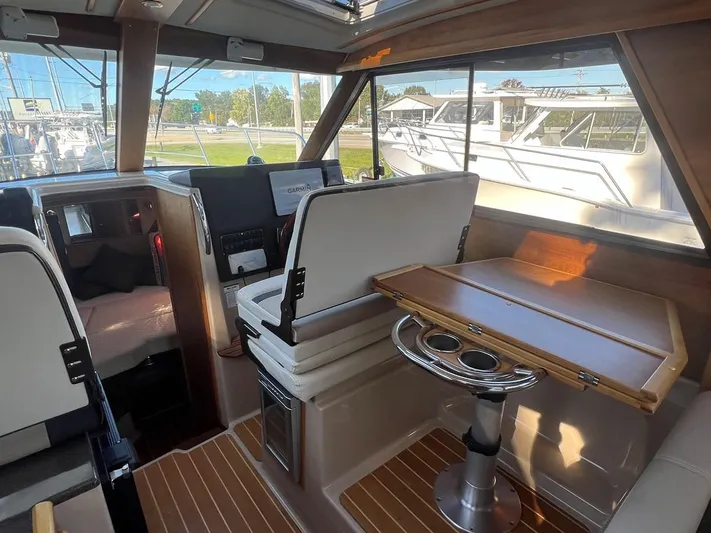  Yacht Photos Pics Interior of 2016 Cutwater C-28 boat with seating and table, showcasing modern design.