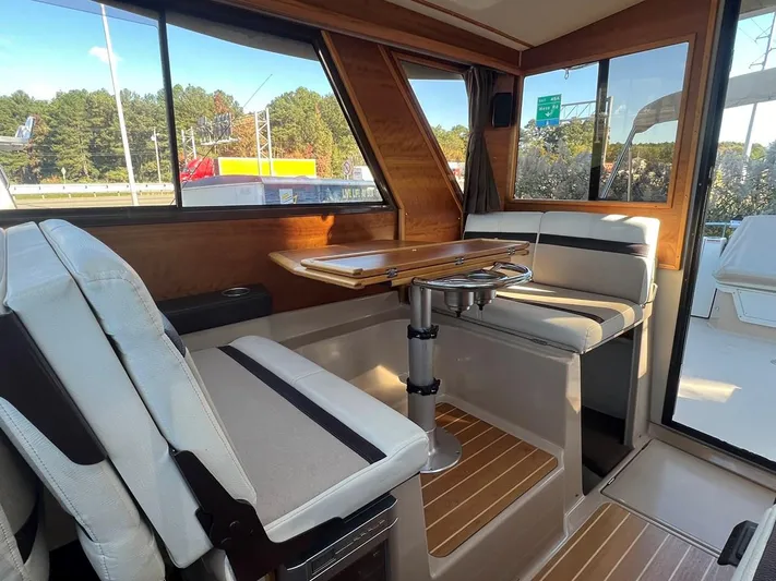  Yacht Photos Pics Interior of 2016 Cutwater C-28 boat with seating and table, featuring wood accents.