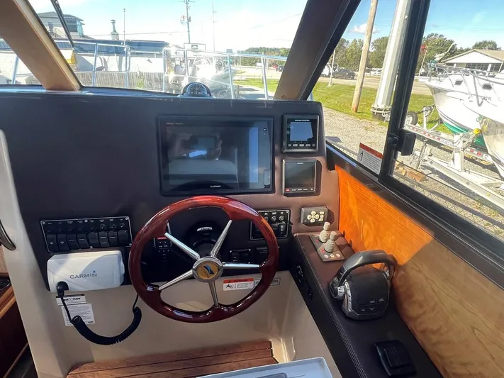  Yacht Photos Pics 2016 Cutwater C-28 helm with Garmin navigation, wooden steering wheel, and control panel.