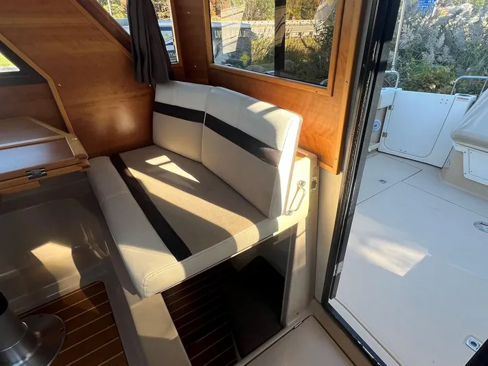  Yacht Photos Pics Interior of 2016 Cutwater C-28 boat with cushioned seating and wooden accents.