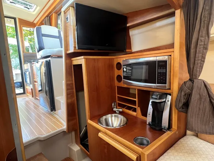  Yacht Photos Pics 2016 Cutwater C-28 interior with kitchenette, featuring microwave, sink, and coffee maker.