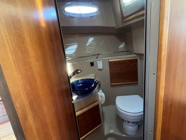  Yacht Photos Pics 2016 Cutwater C-28 boat bathroom with wooden accents and modern fixtures.