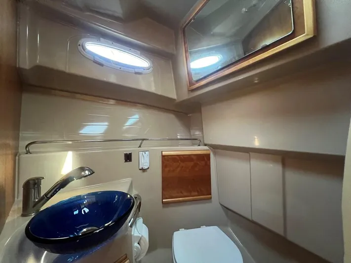  Yacht Photos Pics 2016 Cutwater C-28 boat bathroom with modern sink, mirror, and porthole window.