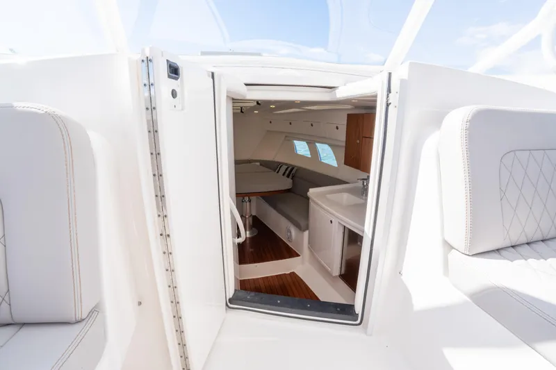  Yacht Photos Pics Interior view of 2019 Intrepid 407 Cuddy boat, featuring seating and kitchenette.