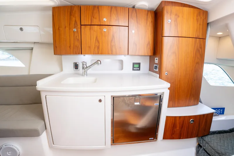  Yacht Photos Pics 2019 Intrepid 407 Cuddy interior with wooden cabinets and modern kitchenette.