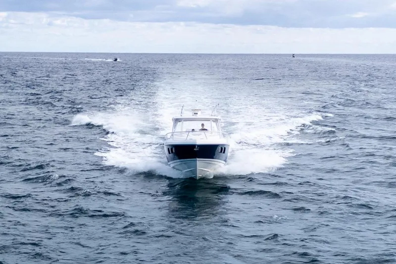  Yacht Photos Pics 2019 Intrepid 407 Cuddy cruising on open ocean under cloudy sky.