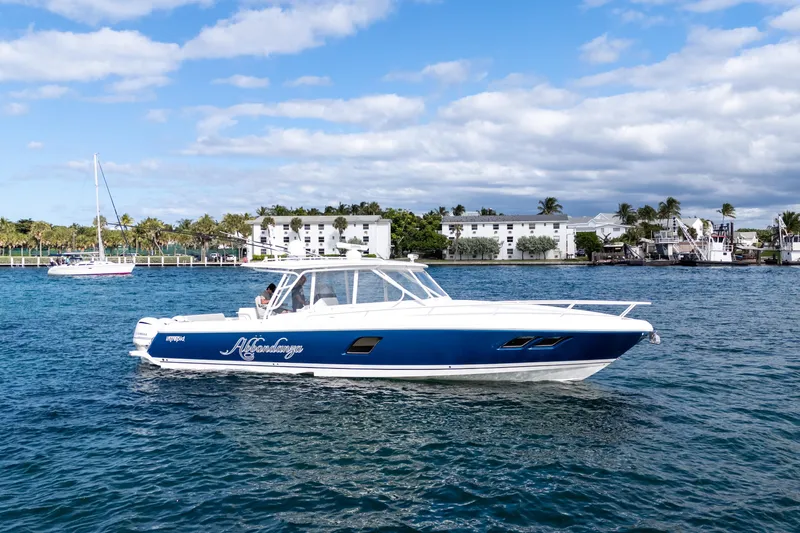  Yacht Photos Pics 2019 Intrepid 407 Cuddy boat on water, blue and white design, coastal background.