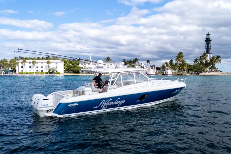  Yacht Photos Pics 2019 Intrepid 407 Cuddy boat cruising near a lighthouse and palm trees.