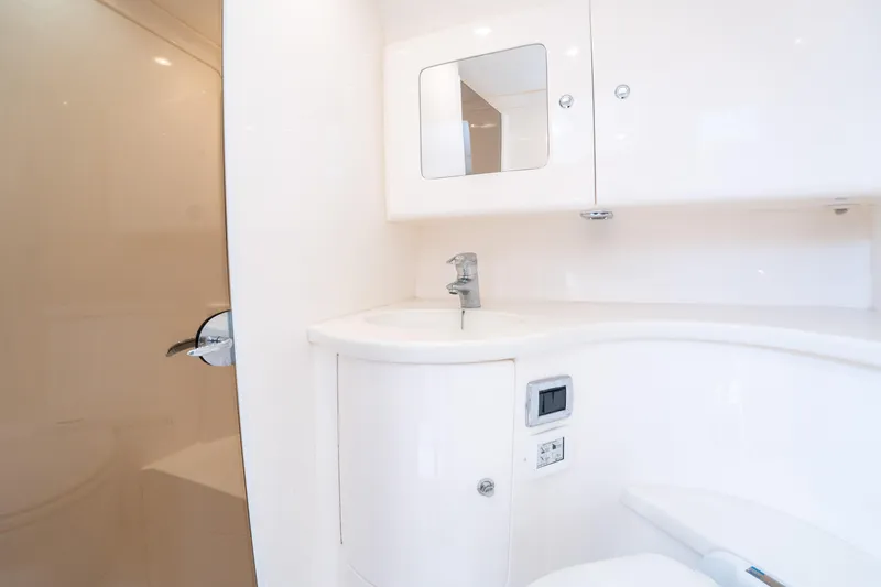  Yacht Photos Pics 2019 Intrepid 407 Cuddy boat bathroom with sleek white cabinetry and modern fixtures.