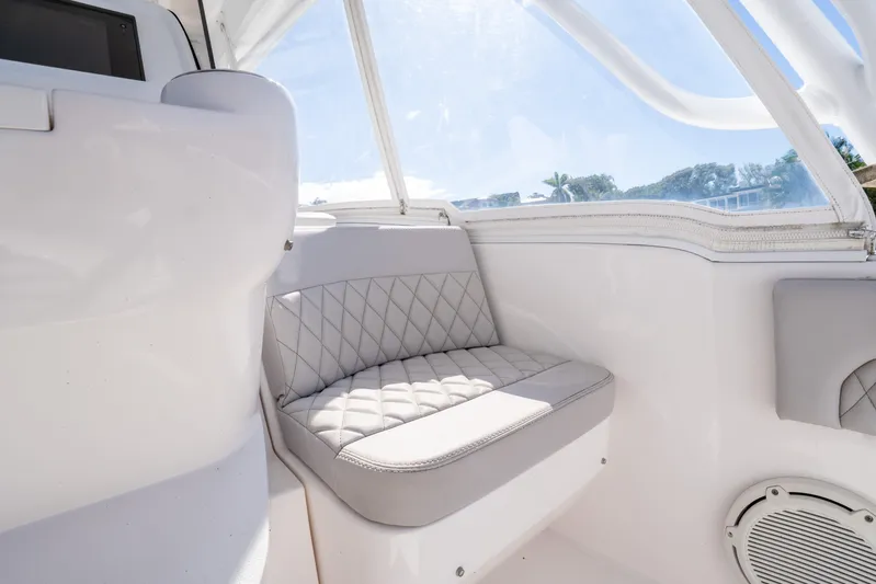  Yacht Photos Pics Interior of 2019 Intrepid 407 Cuddy boat with cushioned seating and window view.