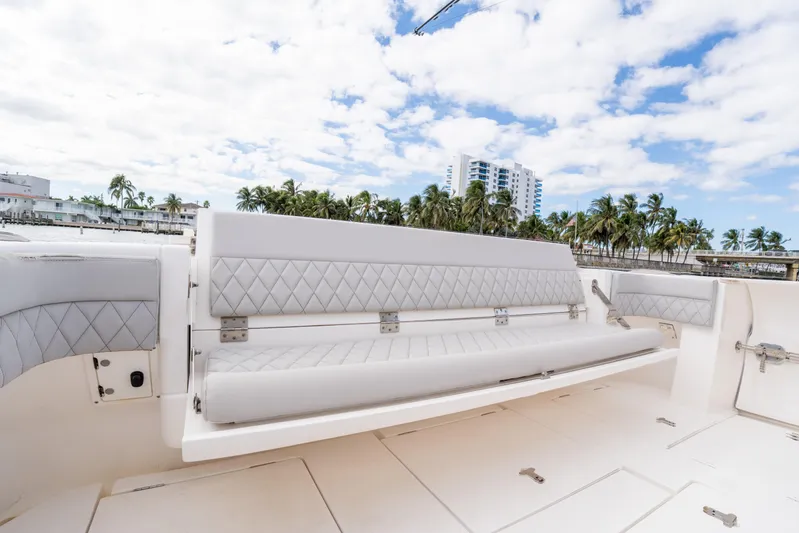  Yacht Photos Pics 2019 Intrepid 407 Cuddy boat with luxurious seating, palm trees, and buildings in the background.