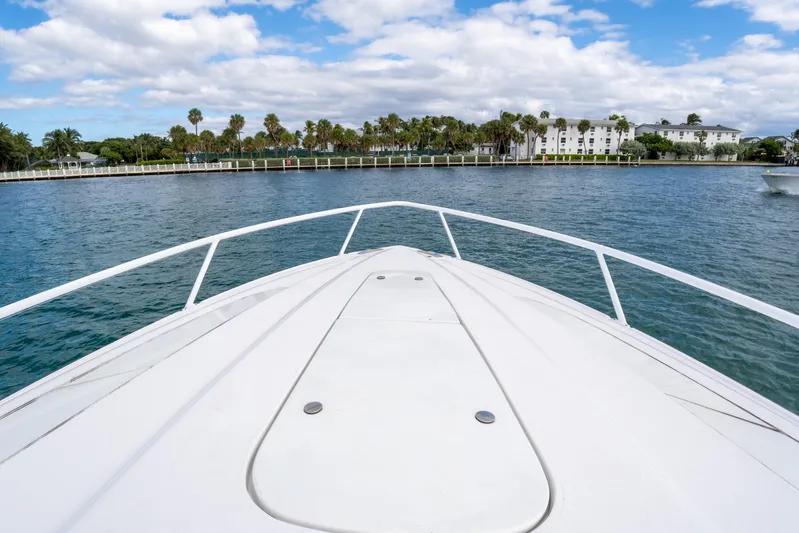  Yacht Photos Pics Bow view of 2019 Intrepid 407 Cuddy on calm water, with scenic shoreline.