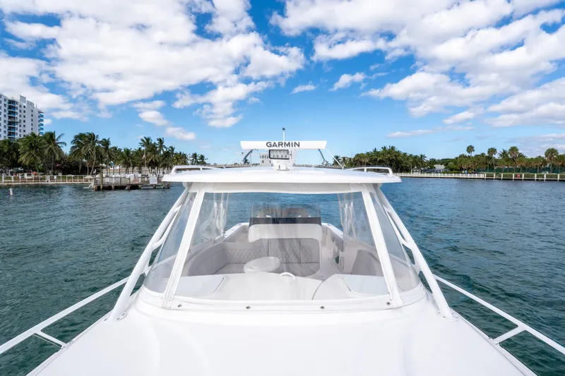  Yacht Photos Pics 2019 Intrepid 407 Cuddy boat cruising on a scenic waterway with palm trees.