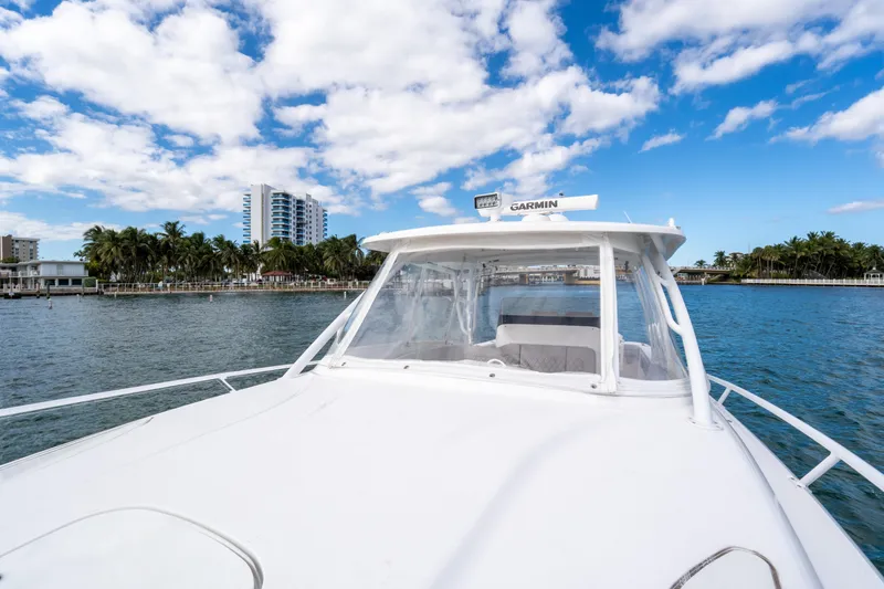  Yacht Photos Pics 2019 Intrepid 407 Cuddy boat on water with cityscape and palm trees in background.