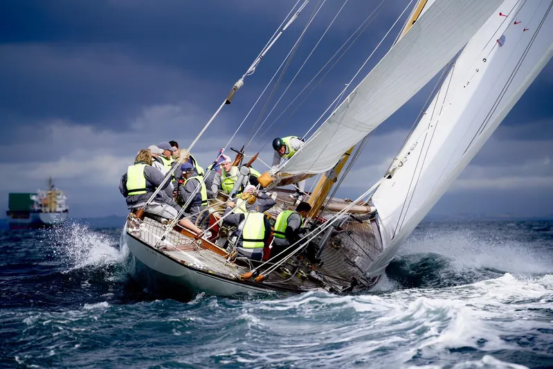 Wings K-15 Yacht Photos Pics Sailors navigating a 1937 Classic 12-metre yacht in rough seas under stormy skies.