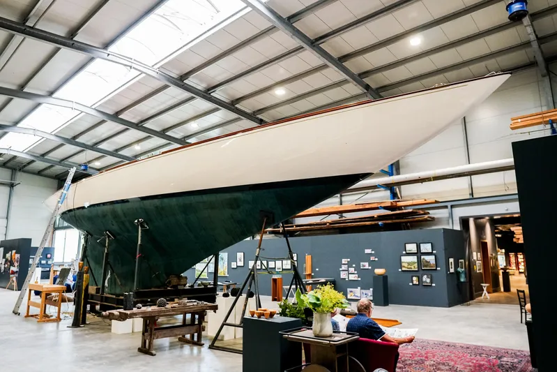 Wings K-15 Yacht Photos Pics 1937 Classic 12-metre yacht displayed in a modern exhibition hall.