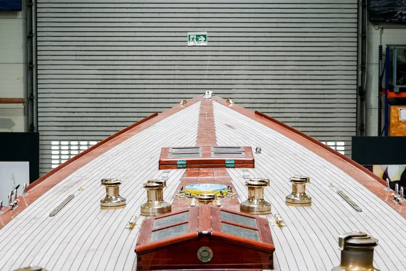 Wings K-15 Yacht Photos Pics 1937 Classic 12-metre yacht deck with polished brass fittings in a workshop.