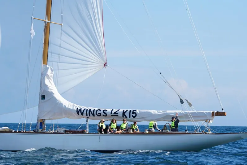 Wings K-15 Yacht Photos Pics Classic 1937 12-metre sailboat "Wings" on the ocean with crew onboard.
