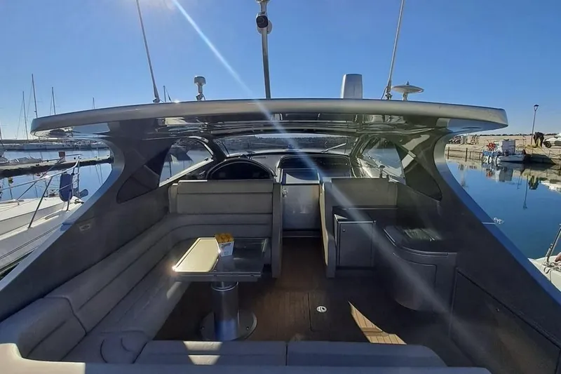 M/y Catch Me Yacht Photos Pics Luxurious 2010 Otam 58 yacht interior with sleek seating and modern design in a sunny marina.