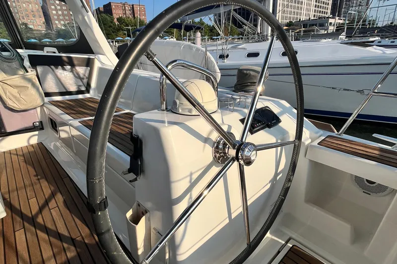 Wind Walker Yacht Photos Pics Steering wheel of a 2013 Beneteau Oceanis 41 sailboat, docked in a marina.