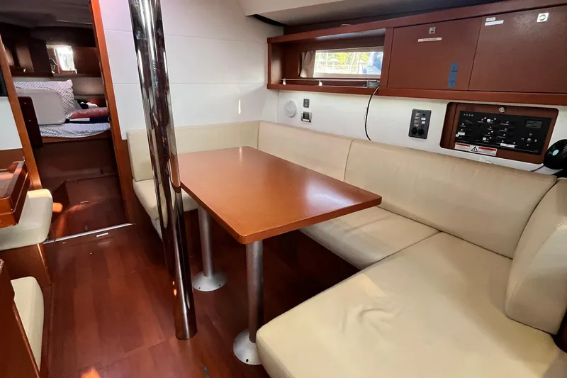 Wind Walker Yacht Photos Pics Interior of 2013 Beneteau Oceanis 41 sailboat with cozy seating and wooden table.