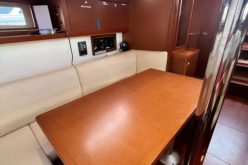 Wind Walker Yacht Photos Pics Interior of 2013 Beneteau Oceanis 41 yacht with wooden table and beige seating.