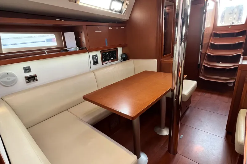 Wind Walker Yacht Photos Pics Interior of 2013 Beneteau Oceanis 41 yacht with wooden table and cream seating.