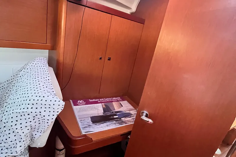 Wind Walker Yacht Photos Pics Interior cabin of 2013 Beneteau Oceanis 41 sailboat with wooden cabinetry and nautical chart.