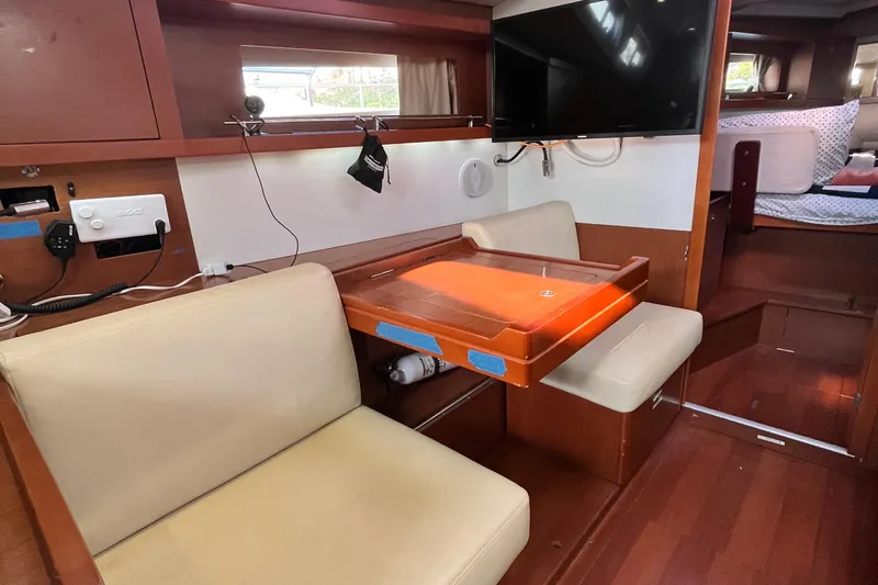 Wind Walker Yacht Photos Pics Interior of 2013 Beneteau Oceanis 41 yacht with seating, table, and mounted TV.