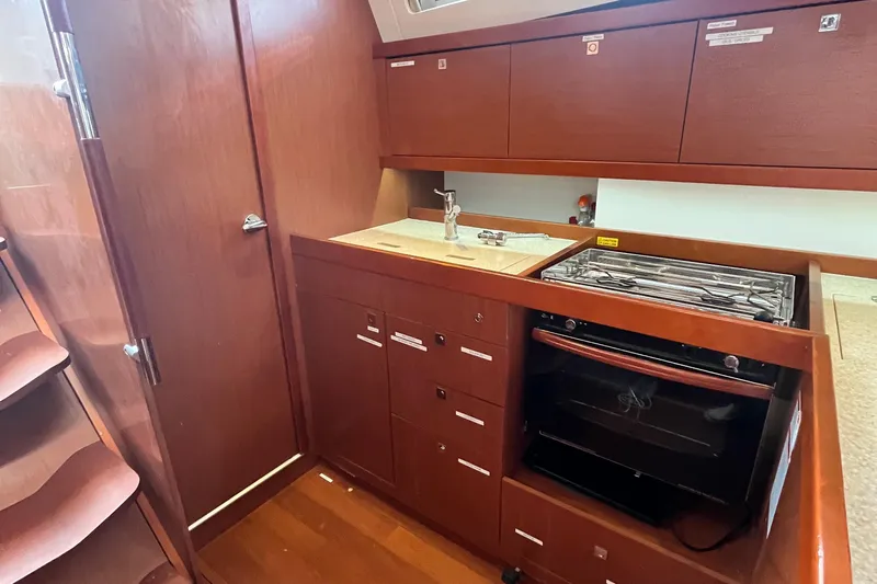 Wind Walker Yacht Photos Pics Interior view of 2013 Beneteau Oceanis 41 yacht kitchen with wood cabinetry and appliances.