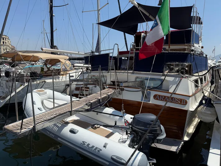 Aramis II Yacht Photos Pics 1990 Grand Banks 49 yacht docked with dinghy and Italian flag.