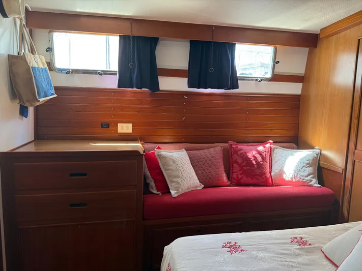 Aramis II Yacht Photos Pics Cozy cabin interior of 1990 Grand Banks 49 with red cushions and wooden accents.